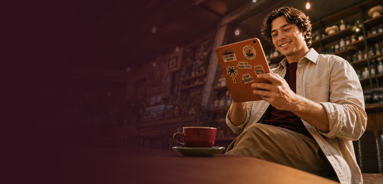 A man using a tablet in a warmly lit café