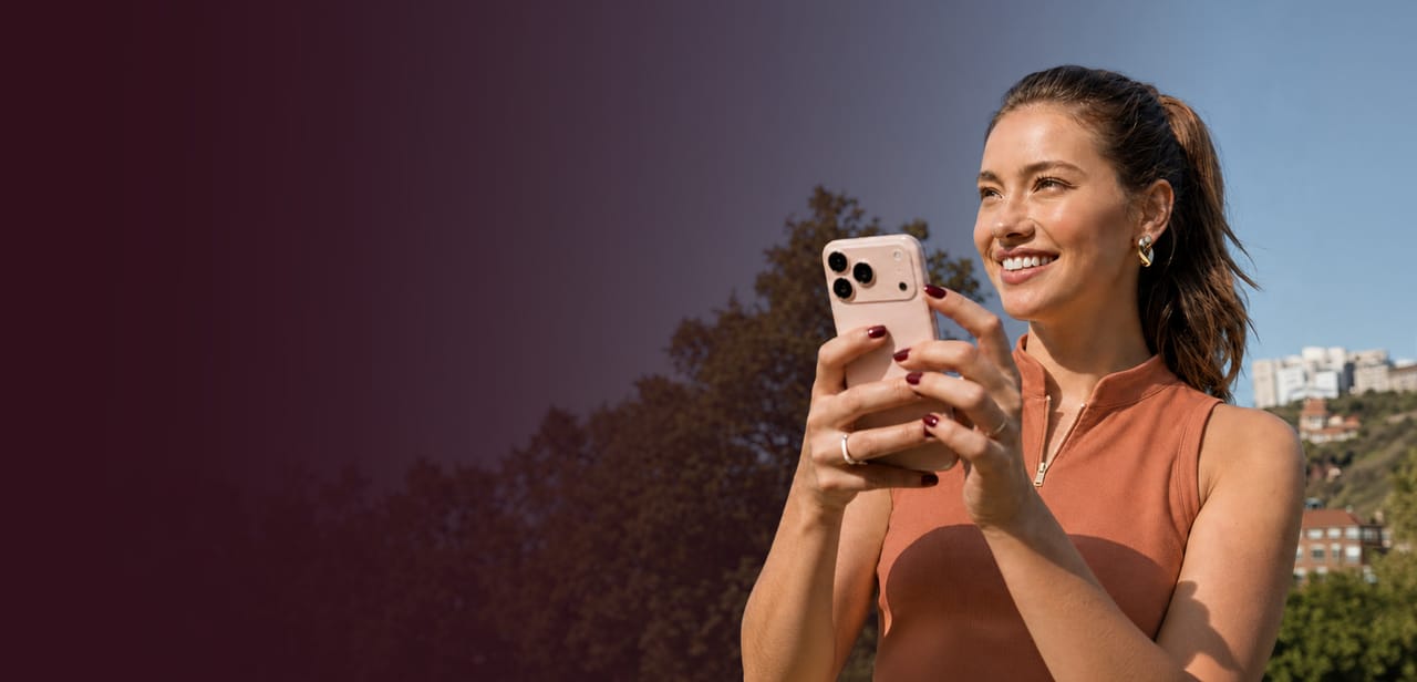 A woman using her phone outdoors on a clear day